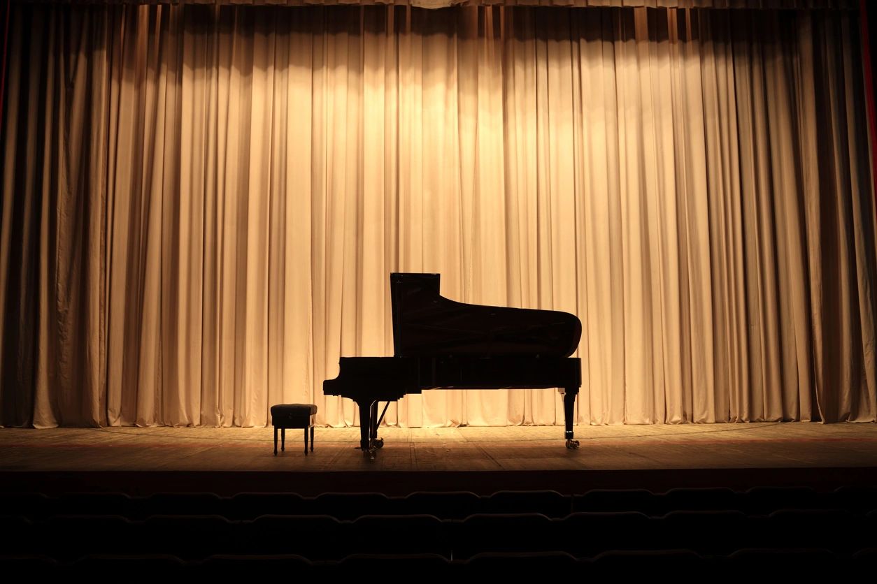 Grand piano silhouette with warm curtains