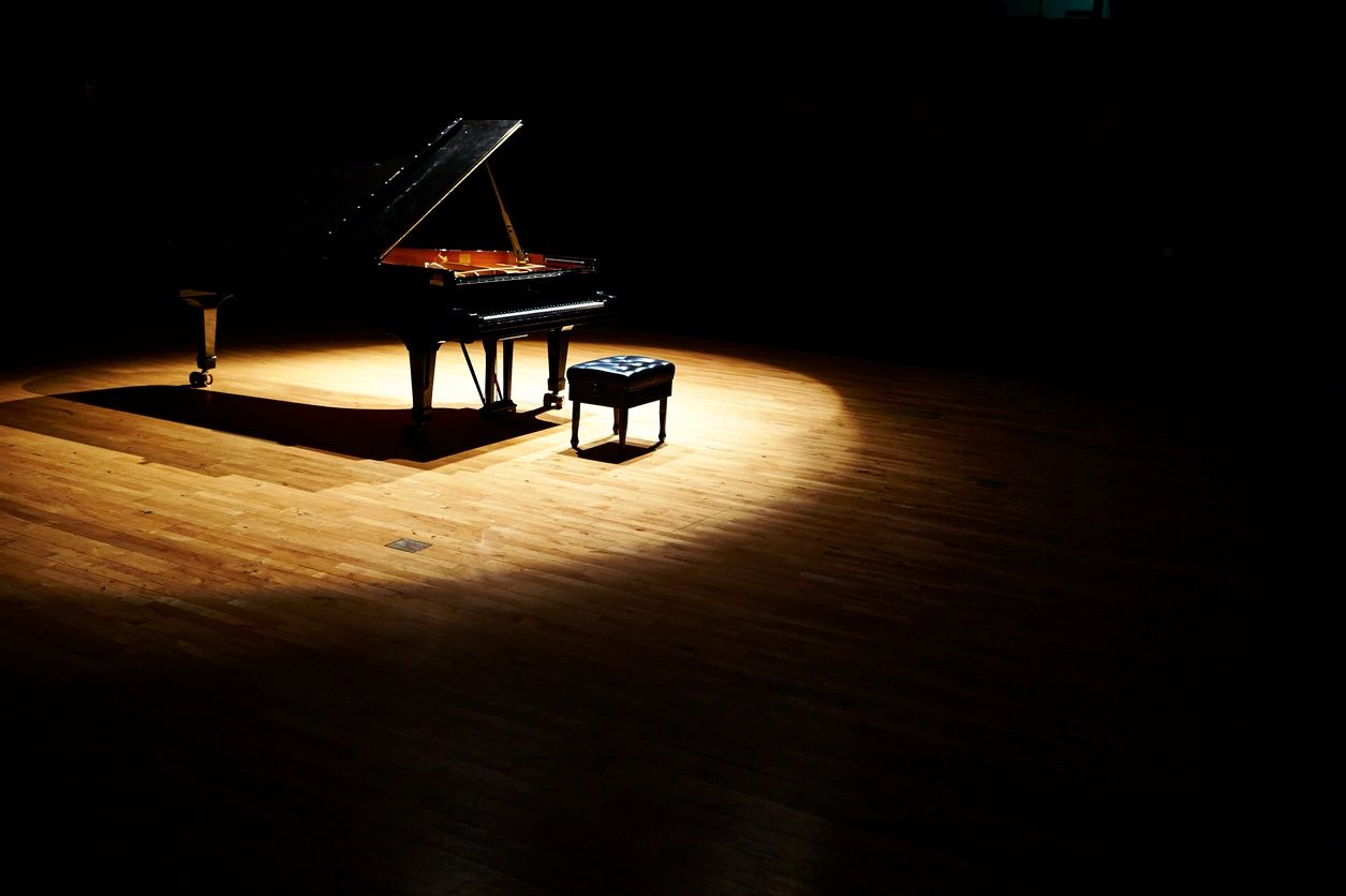 Grand piano under dramatic spotlight